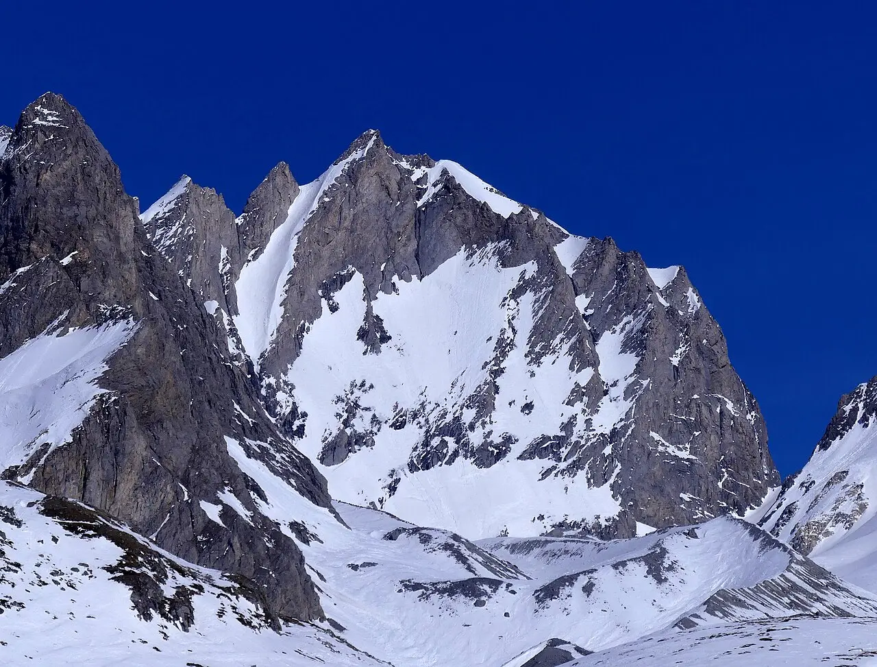 Snow-covered Aiguille de l'Epena and rocky mountain slopes in the French Alps
